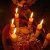 Candlelit altar with angel statue and offerings of a binding spell