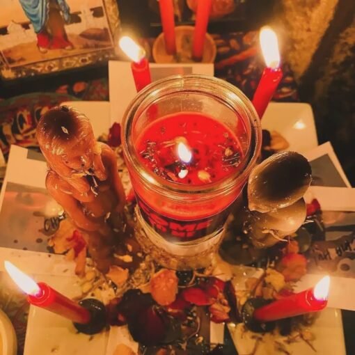 Ritual arrangement with red candles, a jar candle, figurine candles, herbs, and personal objects, symbolizing a powerful reconciliation spells