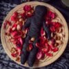 self-love spells Black fabric doll surrounded by rose petals on a wooden platter